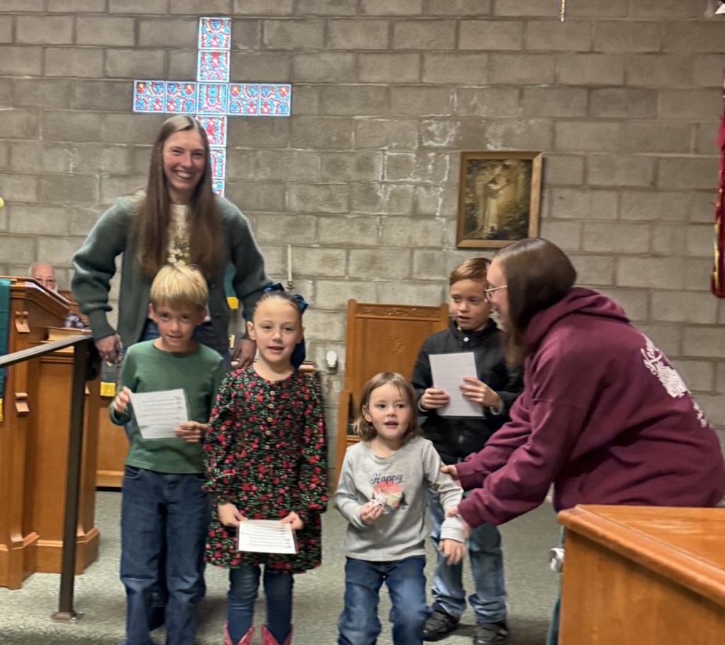 Children participating in an event at Coulterville Community Church, with a cross visible in the background.